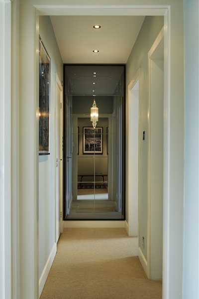 Hallway interior featuring smoked mirror with brilliant cut detailing and wall light